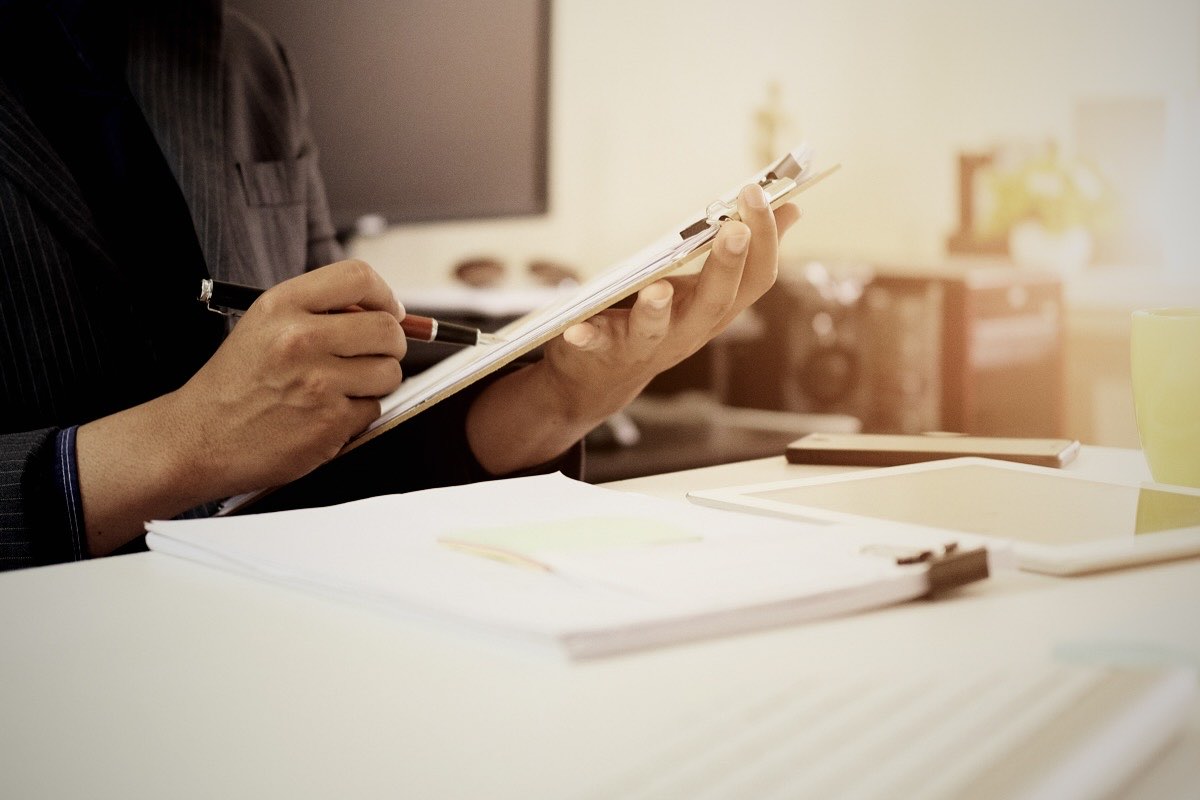 Auditor completing a checklist on a clipboard