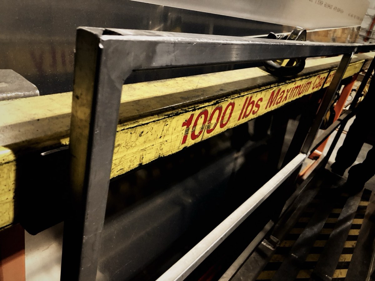Yellow overhead crane rail rated 1000 lbs in a workshop