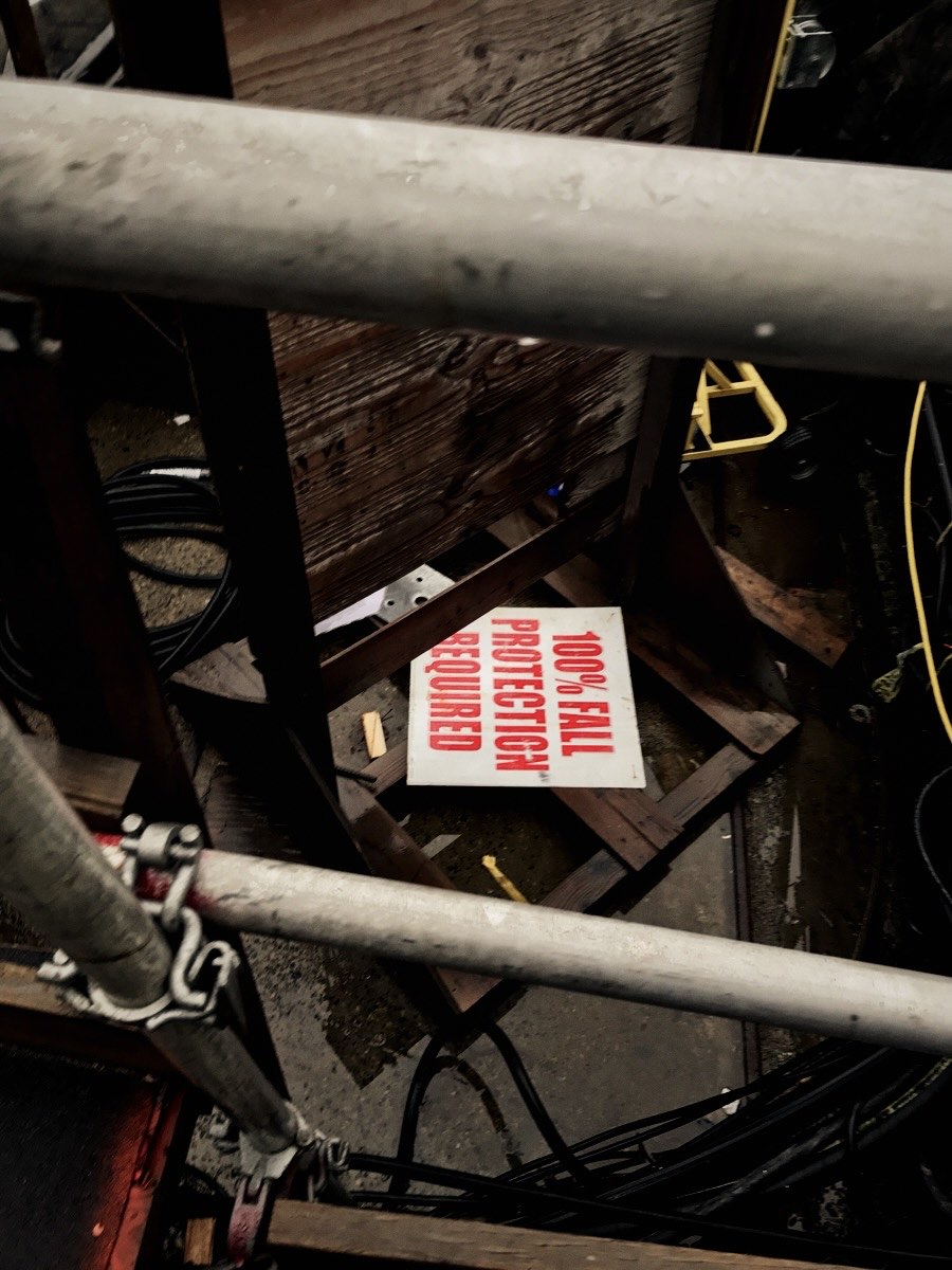Scaffold with a 100% fall protection required sign