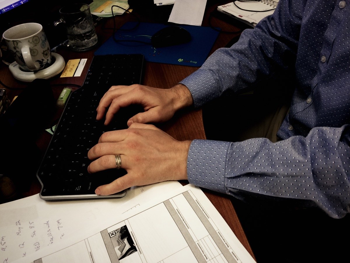 Hands at a keyboard reviewing documents
